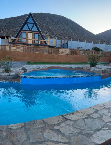 a house with a swimming pool in front of a house at Las Alpinas del valle in Talca