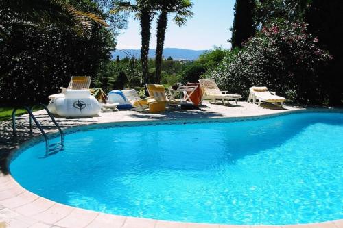 une grande piscine bleue avec des chaises et des chaises dans l'établissement Villa in Frejus with Private Pool & Beach Nearby, cleaning included, à Fréjus