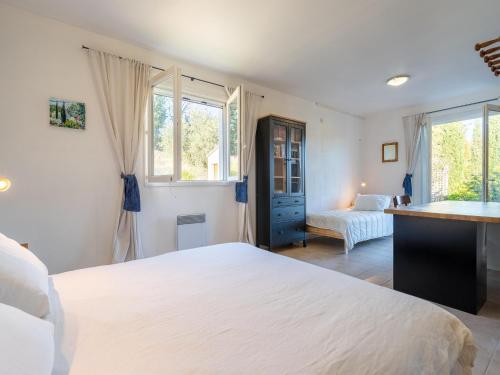 une chambre avec un grand lit blanc et des fenêtres dans l'établissement Holiday Home in Occitanie with Private Pool, cleaning included, à Félines-Minervois