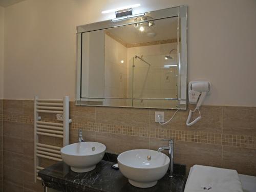 une salle de bain avec deux lavabos et un grand miroir dans l'établissement Villa in Montauroux with Pool & Near Forest, cleaning included, à Montauroux