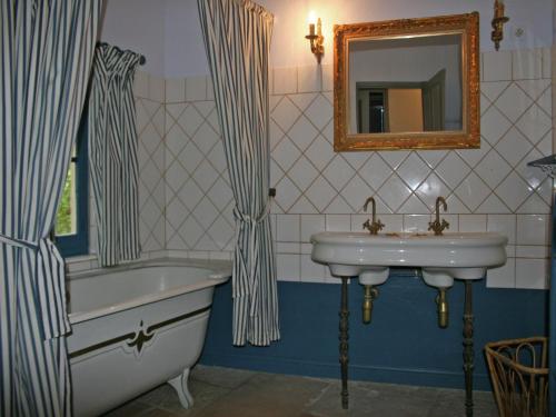 une salle de bain avec une baignoire, un lavabo et un miroir dans l'établissement Holiday Home near Mont Ventoux Pool, cleaning included, à Vaison-la-Romaine