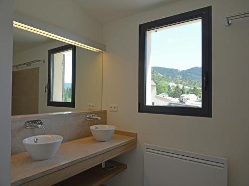 une salle de bain avec deux lavabos et un grand miroir dans l'établissement Villa in Malaucène near Mont Ventoux, cleaning included, à Malaucène