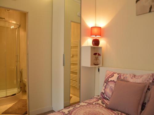 Cette chambre comprend un lit, une lampe et un miroir. dans l'établissement Apartment in Bayeux near Beaches & Tapestry, cleaning included, à Bayeux