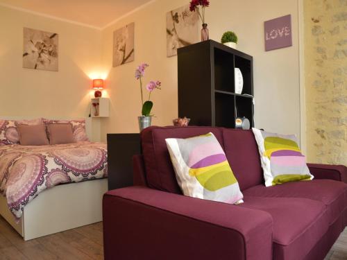 - une chambre avec un canapé violet et un lit dans l'établissement Apartment in Bayeux near Beaches & Tapestry, cleaning included, à Bayeux