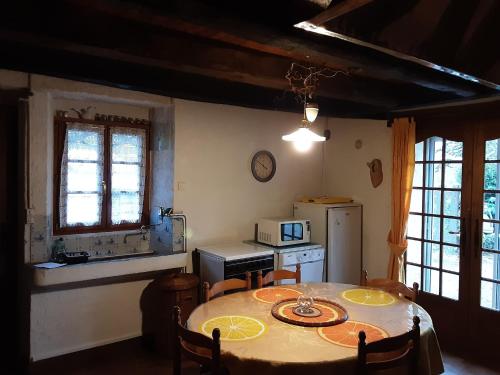une cuisine avec une table avec des chaises et un micro-ondes dans l'établissement Holiday Home in La Chapelle with Garden, cleaning included, à La Chapelle-aux-Bois