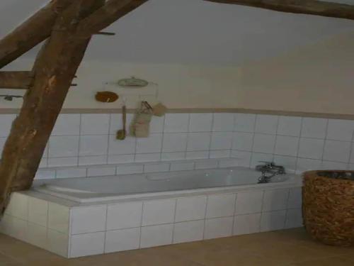Cette chambre dispose d'une baignoire et de carrelage blanc. dans l'établissement Estate in Pyrenees with Pool and Golf Nearby, cleaning included, à Buzon