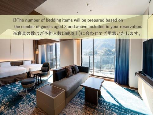 a living room with a couch and a bed at Beppu SUGINOI HOTEL in Beppu