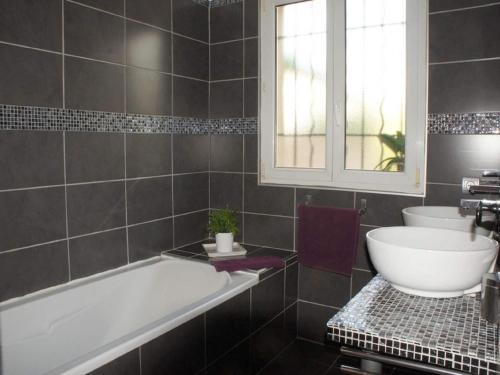 une salle de bain avec une baignoire, un lavabo et une fenêtre dans l'établissement Villa Roquemaure, à Roquemaure