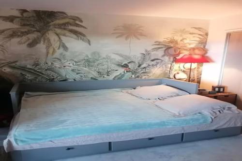 - une chambre avec un lit orné d'une fresque murale de palmiers dans l'établissement Studio in Antibes near the Beach, cleaning included, à Antibes