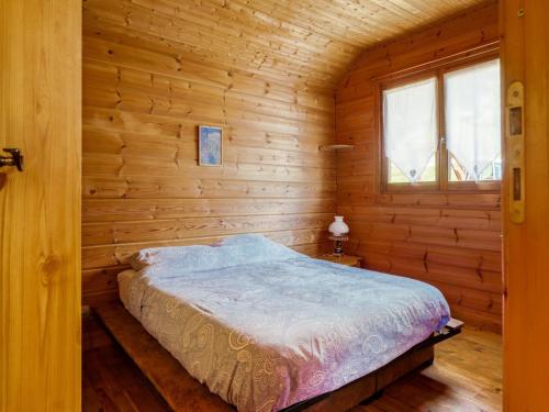 une chambre avec un lit dans une cabane en bois dans l'établissement Chalet in Vosges near Ski Slopes, cleaning included, à Saint-Maurice-sur-Moselle