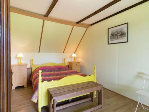 - une chambre avec un lit jaune et une table en bois dans l'établissement Holiday Home in Gouvets near Normandy Coast, cleaning included, à Gouvets