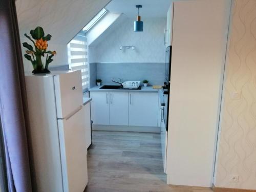 une cuisine avec des armoires blanches et un réfrigérateur blanc dans l'établissement Holiday Home in Normandy near Coastline, cleaning included, à Port-en-Bessin-Huppain