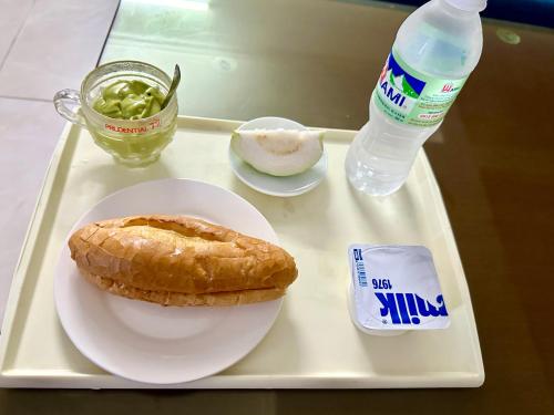 a tray with a plate of food and a bottle of water at Family Transit Hotel Nội Bài in Hanoi