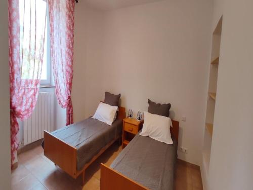 deux lits dans une petite pièce avec une fenêtre dans l'établissement Farmhouse in Ardèche near Vallon Pont d'Arc, cleaning included, à Sanilhac