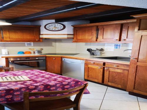 une cuisine avec une table et une horloge au mur dans l'établissement Chalet in La Bresse near Ski Slopes, cleaning included, à Le Ménil