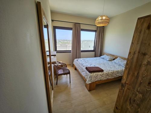 a bedroom with a bed and a chair and a window at Private villa - Azha Ein Sokhna - Families only in Ain Sokhna