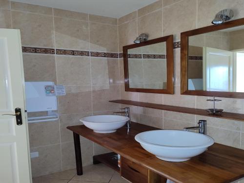 une salle de bain avec deux lavabos et un miroir dans l'établissement Alpine Chalet Retreat with Pool, cleaning included, à Serrières-en-Chautagne