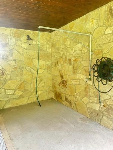 a shower in a stone wall with a spider on it at Chalupa u Golisov in Zákopčie