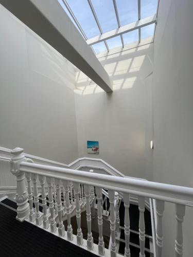 a white staircase with a skylight in a building at Nomads Capital Backpackers - Wellington in Wellington