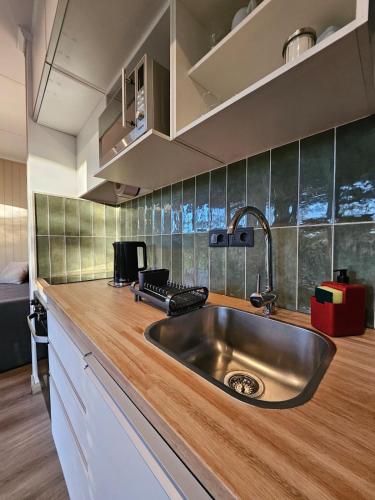 a kitchen with a sink and a wooden counter top at La Recompensa Tiny in Colonia Nuevo Paysandú