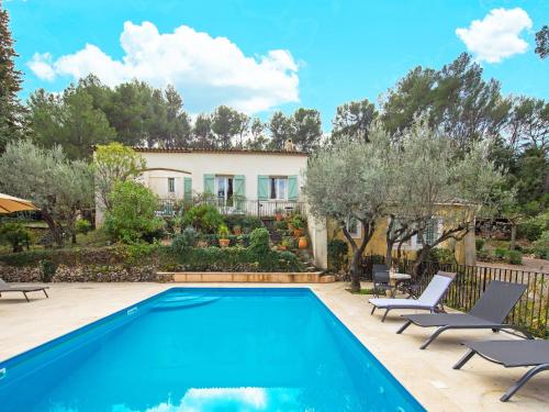 une piscine avec des chaises et une maison en arrière-plan dans l'établissement Villa in Provence with Pool and Charm, cleaning included, à Draguignan
