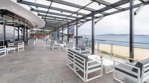 a restaurant with white chairs and a view of the ocean at Crowne Plaza Residences Port Moresby by IHG in Port Moresby