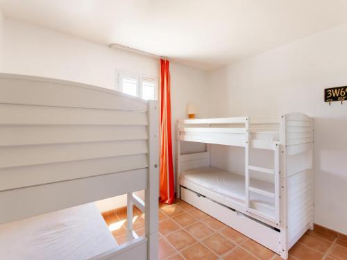 - une chambre avec 2 lits superposés et un rideau orange dans l'établissement Holiday Home in Arles with Pool & Terrace, cleaning included, à Arles