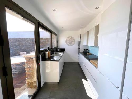 une cuisine avec des placards blancs et une grande fenêtre dans l'établissement Villa in Gaou with Sea View and Beach, cleaning included, à Bormes-les-Mimosas