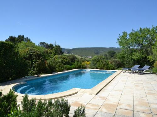 une piscine avec deux chaises longues à côté dans l'établissement Modern villa with private pool in Cesseras, cleaning included, à Cesseras