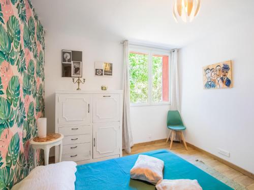 une chambre avec un lit bleu et une fenêtre dans l'établissement Holiday Home near Lake Quinson and Moustiers, cleaning included, à Montmeyan