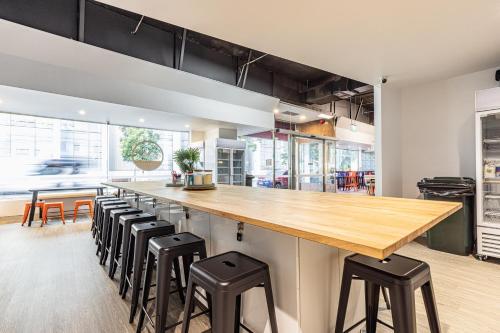 a kitchen with a long counter with stools at Tequila Sunrise Podstel Brisbane in Brisbane