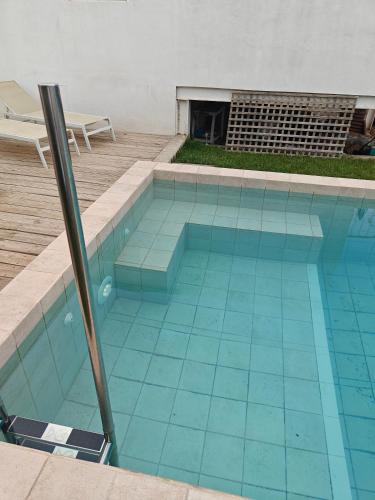 a swimming pool with blue tiles on the floor at Casinhas Vale de Mouro in Melides
