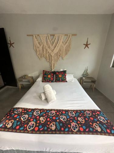 a bed with a colorful blanket and pillows on it at Saela Hotel Boutique in Playa del Carmen