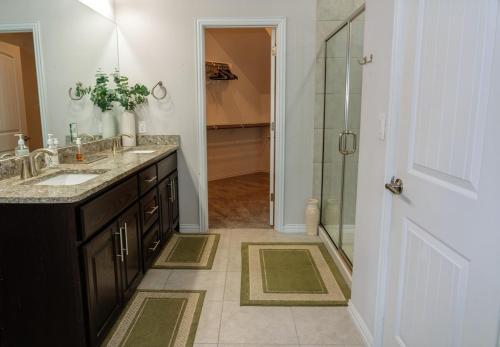 a bathroom with two sinks and a glass shower at Spacious Retreat - 3 King Beds - Free Parking in Austin