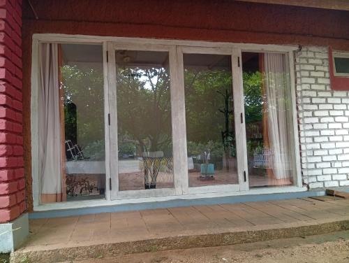 a window on the side of a house with curtains at Mahi's Place in Minneriya