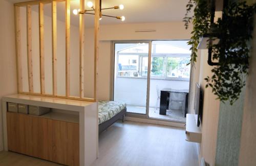 - un salon avec une grande fenêtre et une télévision dans l'établissement Studio proche de la mer, à Saint-Mandrier-sur-Mer