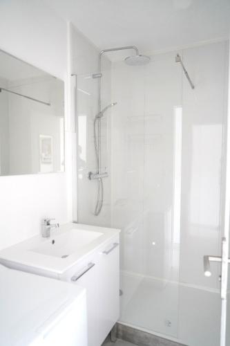 une salle de bain blanche avec un lavabo et une douche dans l'établissement Studio proche de la mer, à Saint-Mandrier-sur-Mer