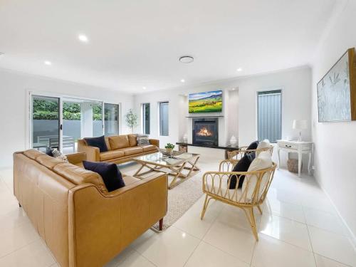 a living room with two couches and a fireplace at Relaxed Luxury for Families by the Beach in Buddina