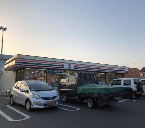a car and a truck parked in front of a gas station at 古民家一棟貸子犬と画家みんなの家 in Kosai