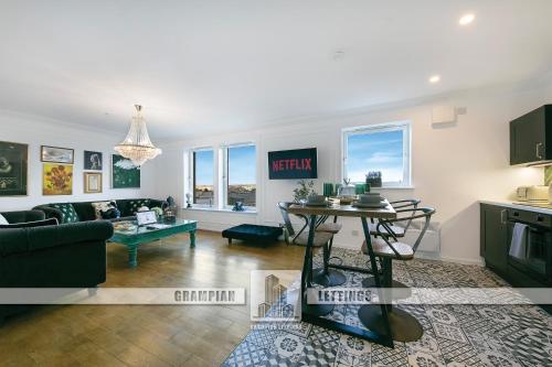 a living room with a couch and a table at Bohemian Raphsody Apartment ✪ Grampian Lettings Ltd in Aberdeen