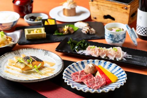 a table with plates of food on a table at Panorama Inn Yamanakako in Yamanakako