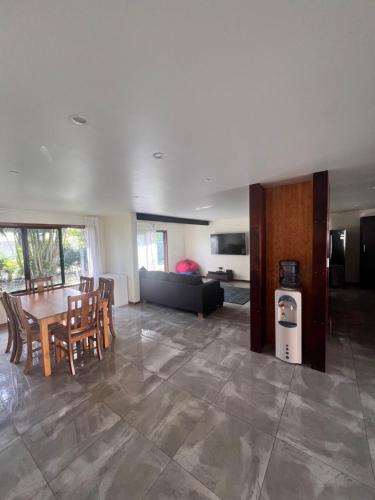 a living room with a table and chairs and a couch at Atupa Holiday Home in Rarotonga