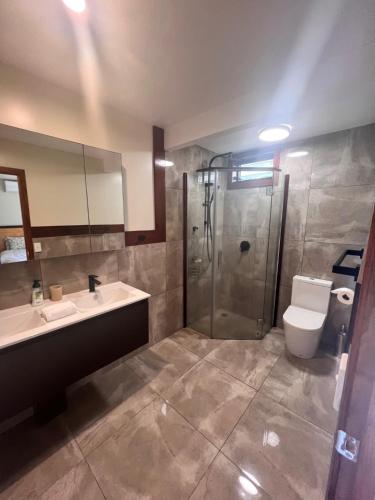a bathroom with a shower and a toilet and a sink at Atupa Holiday Home in Rarotonga