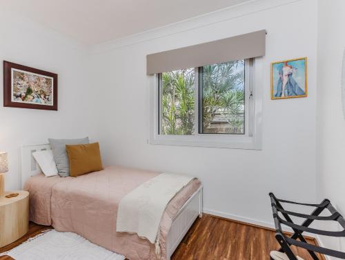 a bedroom with a bed and a window at Caba Beach Condo Modern, 2-bedroom cabin, walk to the beach! 3-night minimum stay in Cabarita Beach