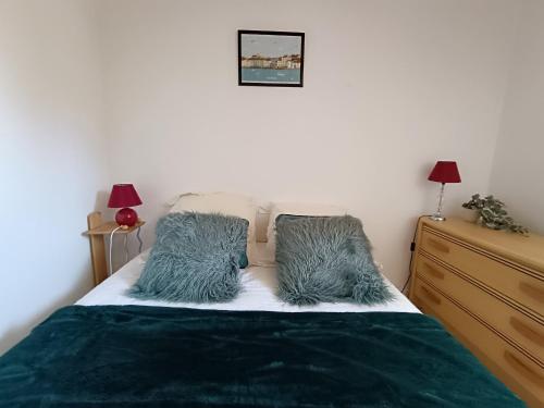 une chambre avec un lit avec des oreillers bleus dessus dans l'établissement Maison bord de mer, 4 couchages, terrasse privée, à 50m de la plage ! - FR-1-364-104, à Saint-Brévin-les-Pins