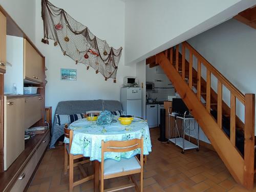 une cuisine et une salle à manger avec une table et un escalier dans l'établissement Maison bord de mer, 4 couchages, terrasse privée, à 50m de la plage ! - FR-1-364-104, à Saint-Brévin-les-Pins