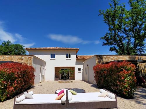 a courtyard with two couches in front of a house at Modern Villa with Pool in Montauroux France in Montauroux