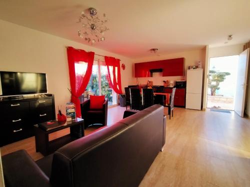 a living room with a couch and a kitchen with red curtains at Modern Villa with Pool in Montauroux France in Montauroux