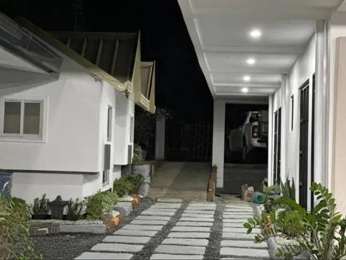 a white house with a porch and a driveway at Guest House in Agoo La Union in Agoo