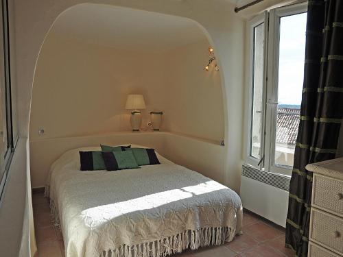 une chambre avec un lit et une grande fenêtre dans l'établissement Village House in Fayence with Castle Views, cleaning included, à Fayence